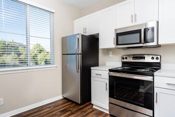 A kitchen with white cabinets and stainless steel appliances